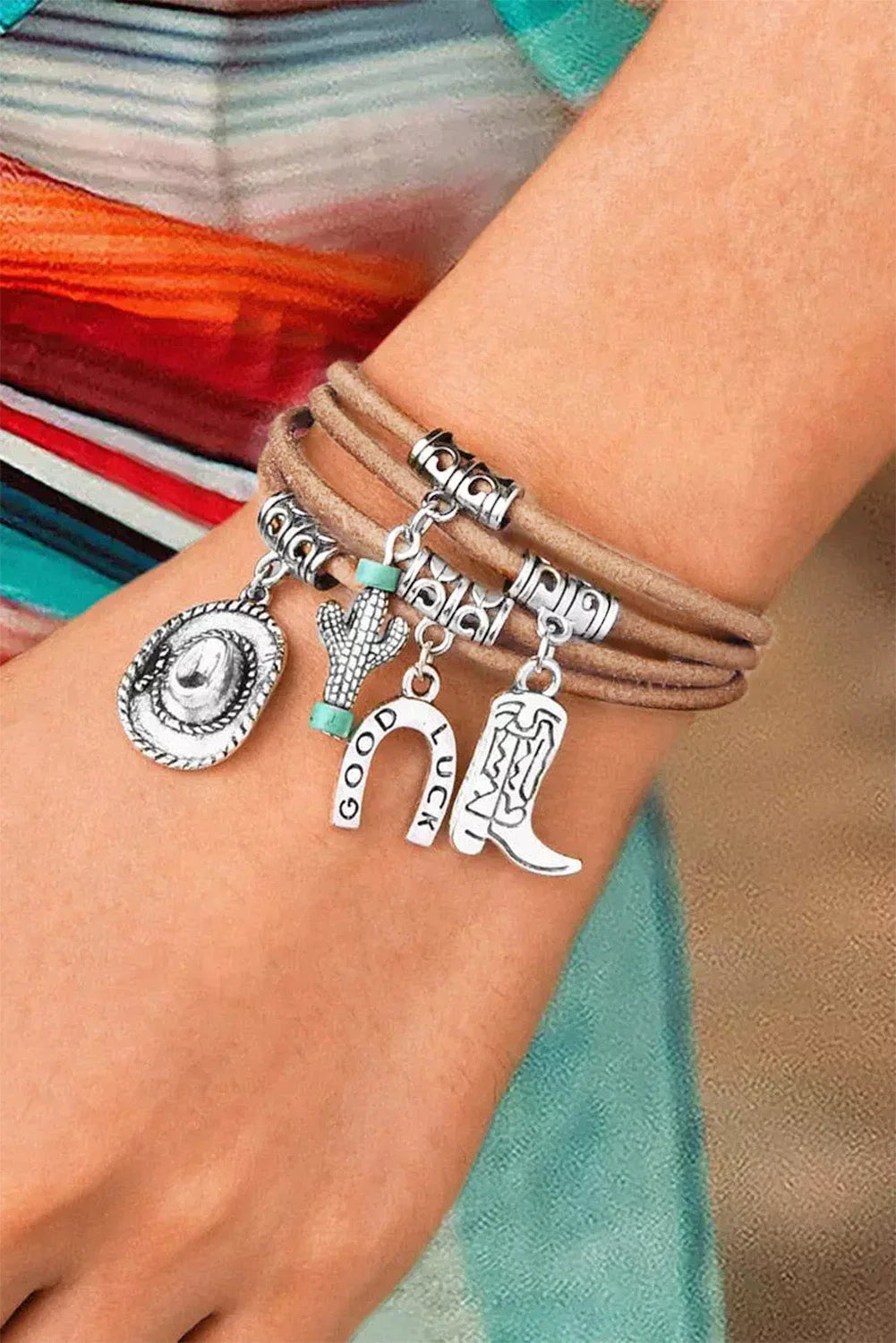 Women's multi-layered western charm bracelet with hat, boot, and cactus charms in silver tone. Cowgirl fashion.