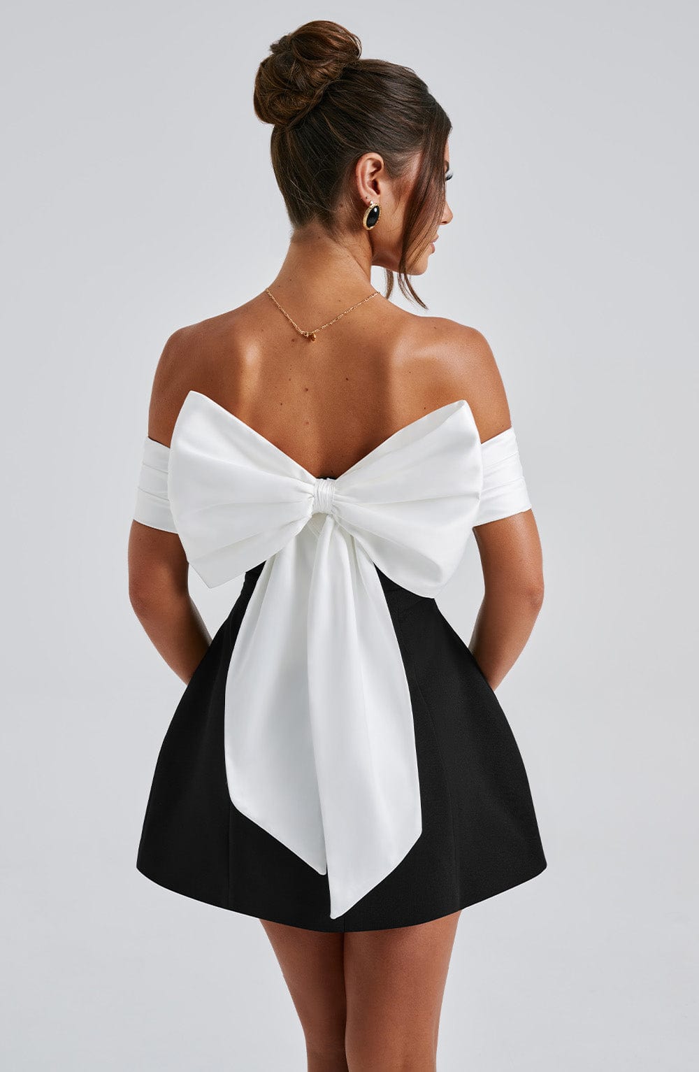 Stylish women's off-shoulder party mini dress with a lovely bow back and playful flared skirt.