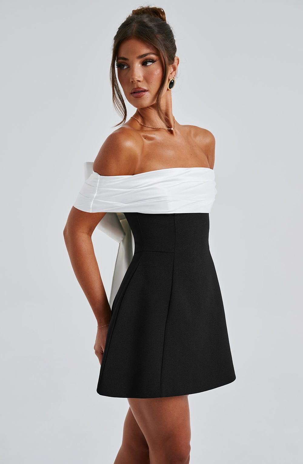 Women's elegant off-shoulder mini dress, perfect for parties, with a flared skirt and chic bow back.