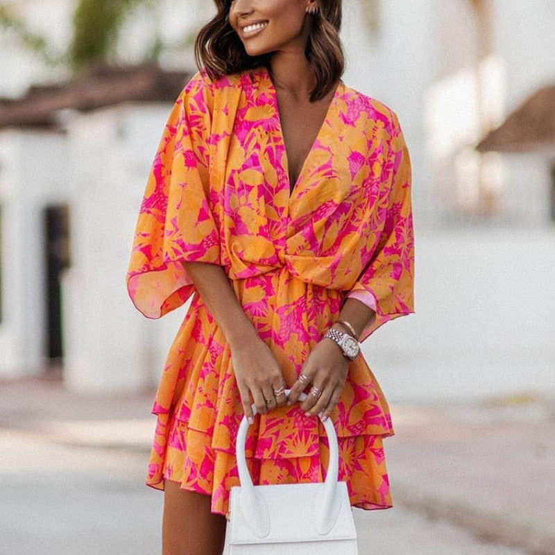Stylish women's floral mini dress featuring a ruffle hem, v-neck, and batwing sleeves, ideal for summer fashion.