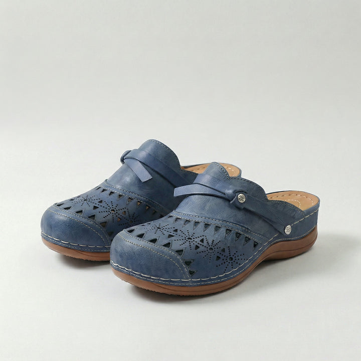 Women's orthopaedic perforated mule clogs with arch support for all-day comfort.