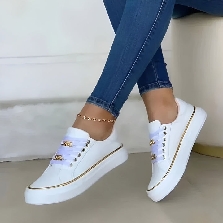 Chic women's trainers featuring golden accents, designed for comfort, arch support, and stylish daily walking.