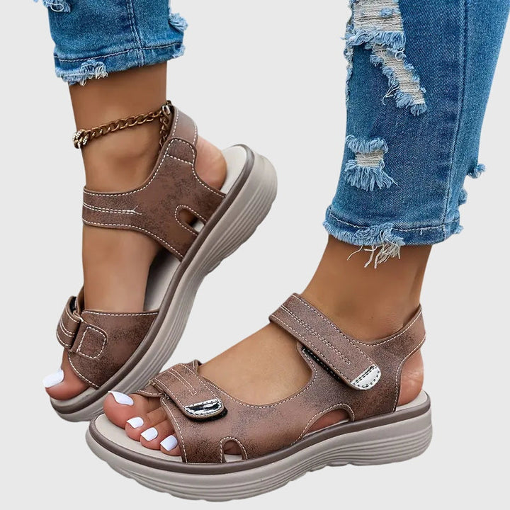 Woman walking comfortably in orthopedic sandals, providing arch & posture support for relief.