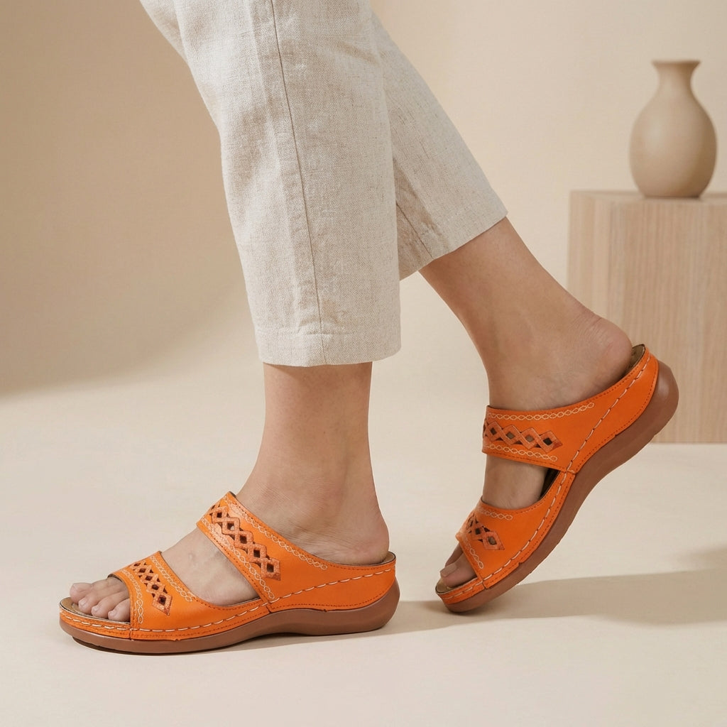Chic women's comfort sandals with intricate laser-cut detailing on double straps.