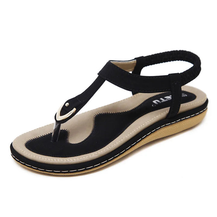 Stylish women's T-strap flat sandals with orthopedic arch support for casual summer comfort.