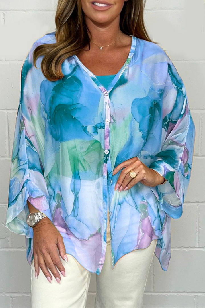 Stylish women's oversized button-down blouse featuring a unique abstract print, v-neck, and long sleeves. Modern fashion.