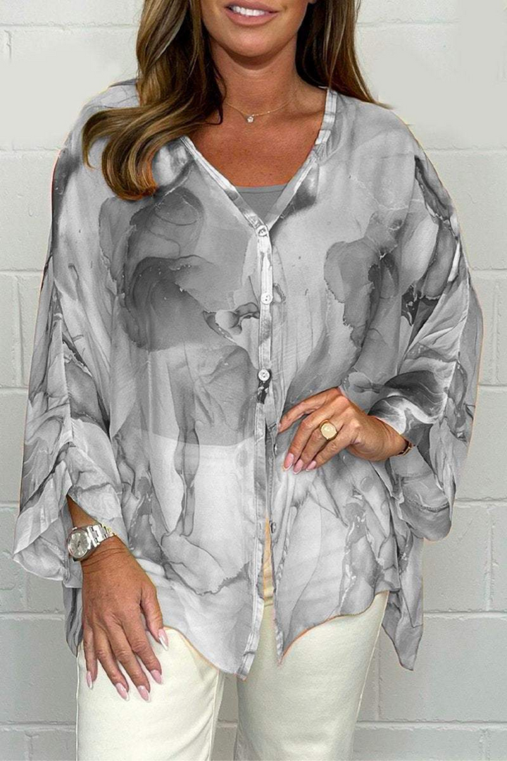 Comfortable oversized women's blouse, showcasing a vibrant abstract print. Long sleeve, v-neck for a stylish, modern look.