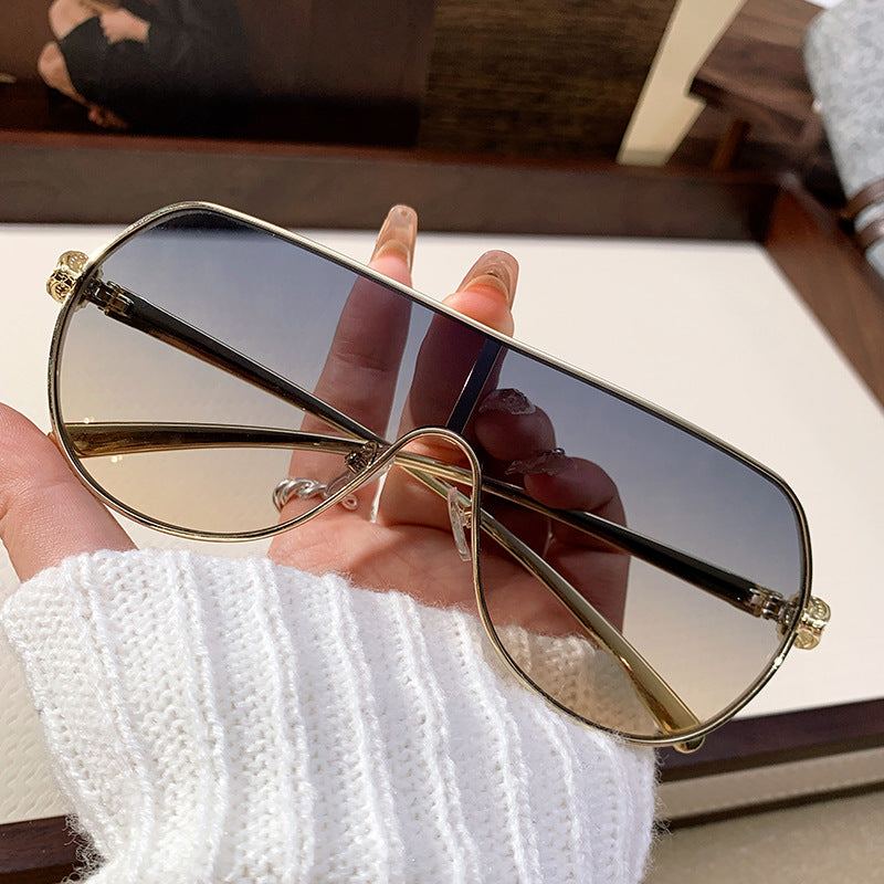 Elegant women's oversized aviator sunglasses, sleek metal frame, offering stylish UV protection.