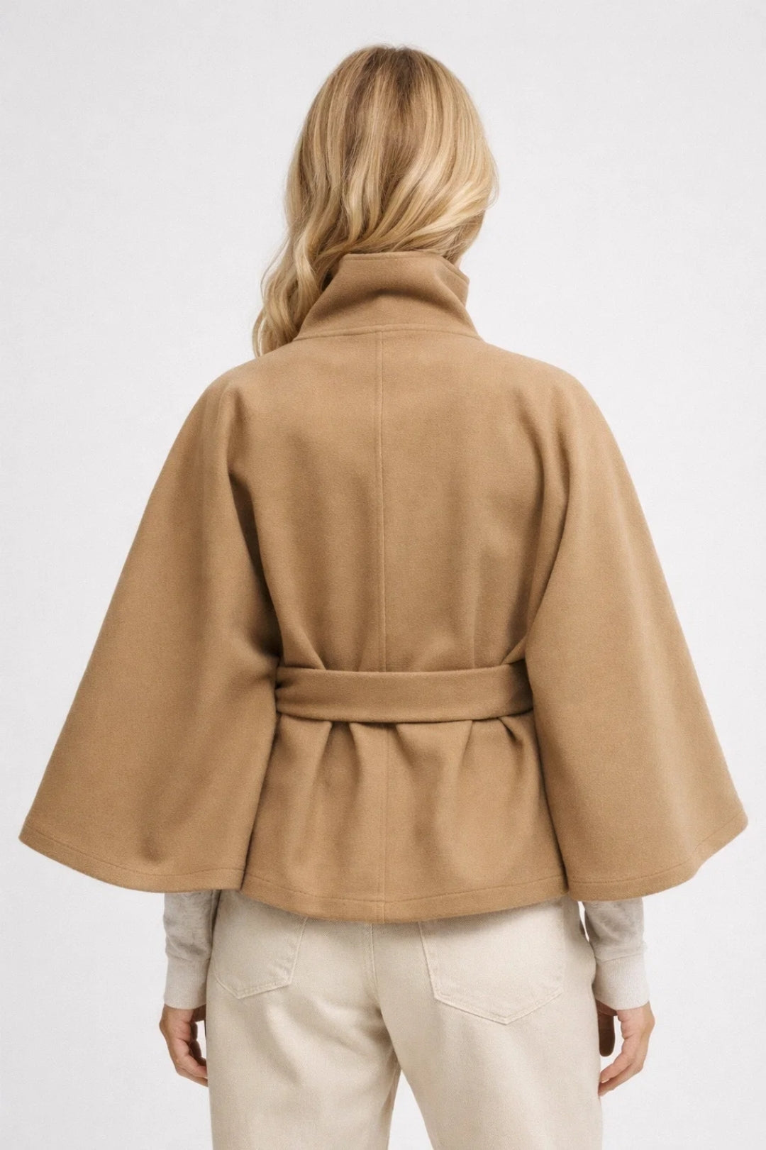 Elegant women's oversized outerwear, a fashionable short coat with a defining belt and high collar.