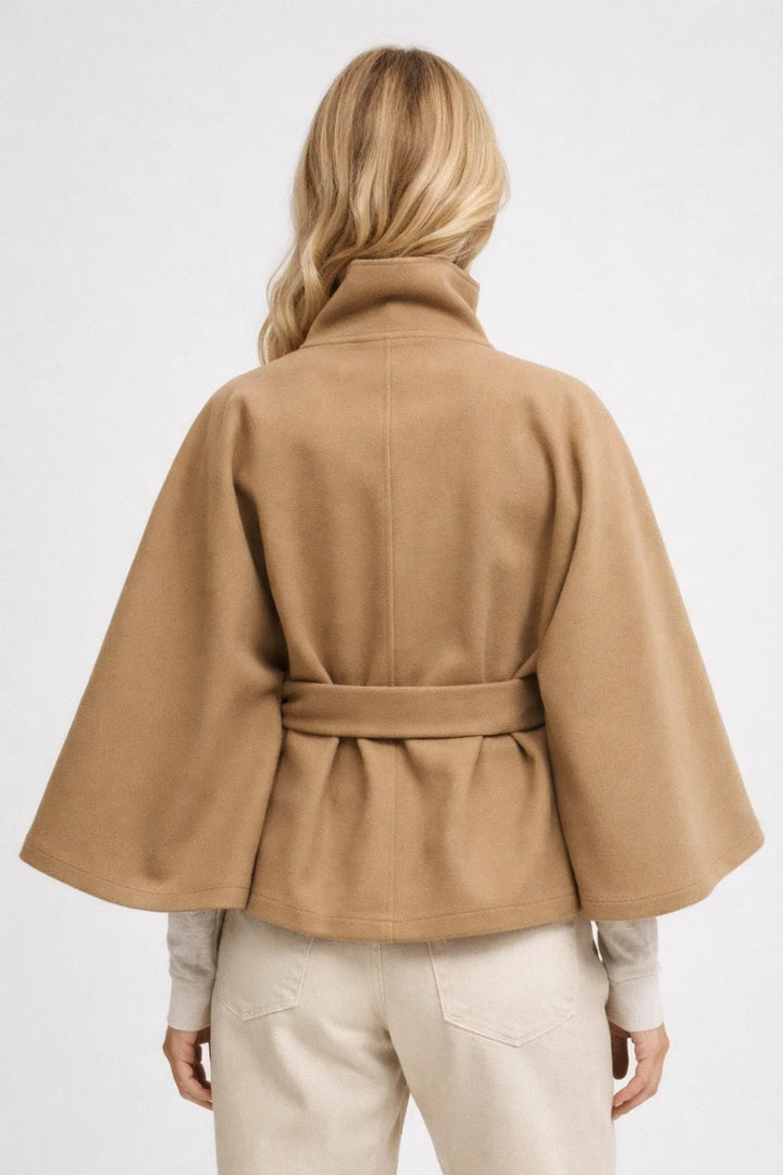 Elegant women's oversized outerwear, a fashionable short coat with a defining belt and high collar.