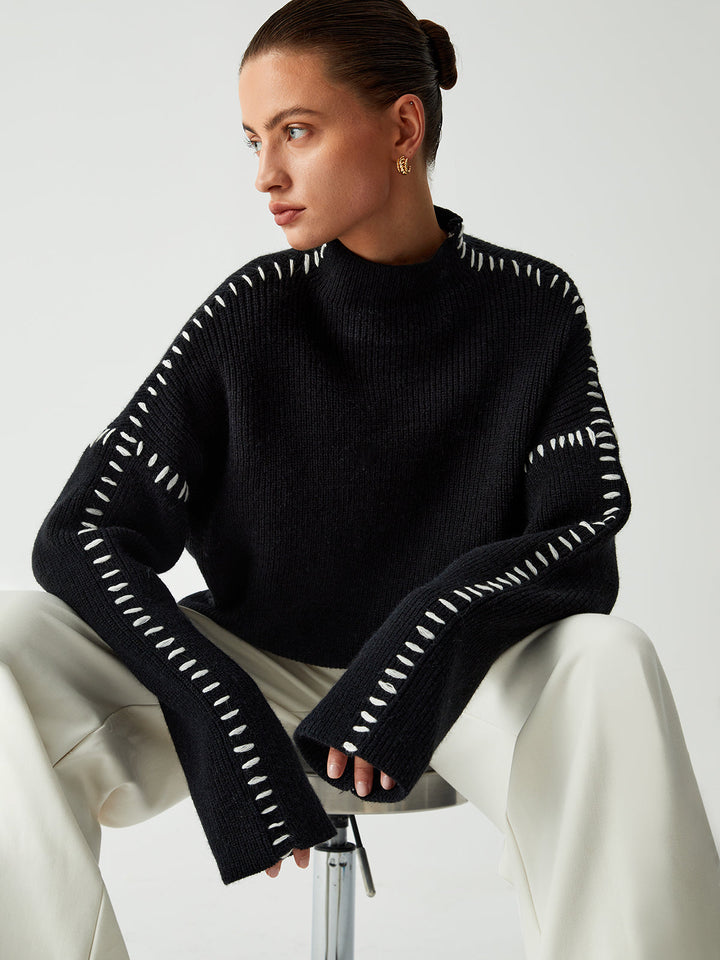 Modern black oversized sweater for women featuring unique contrast stitching and a comfortable mock neck, ideal for fall/winter.