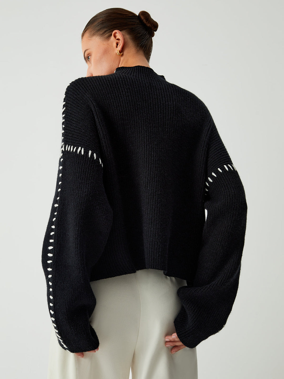 Chic women's black oversized sweater with contrast stitch detail & mock neck, great for casual winter fashion & everyday wear.