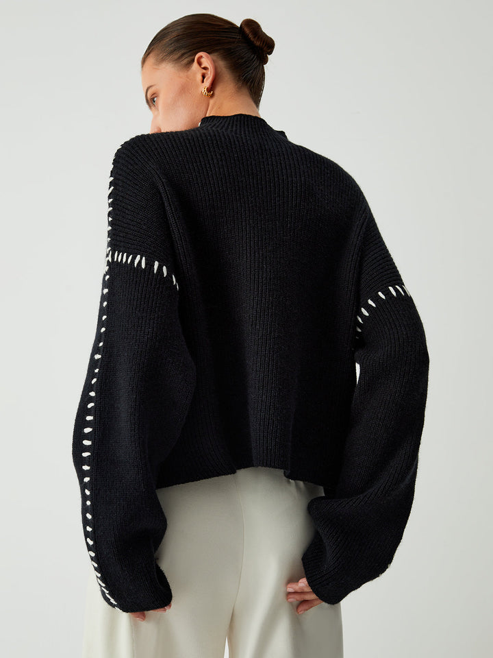 Chic women's black oversized sweater with contrast stitch detail & mock neck, great for casual winter fashion & everyday wear.