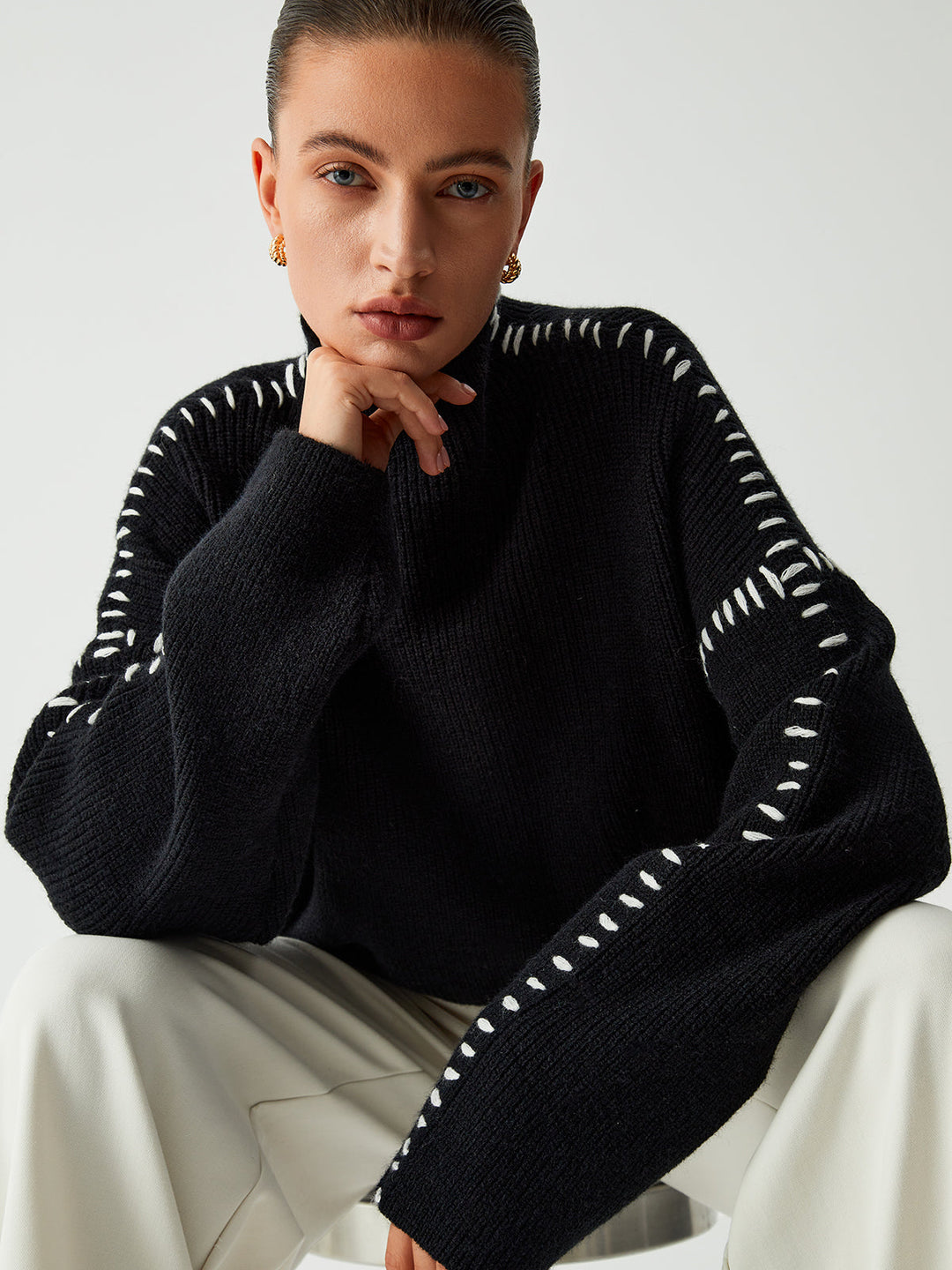 Cozy black oversized women's sweater with contrast stitching & mock neck, offering relaxed comfort for fall and winter.