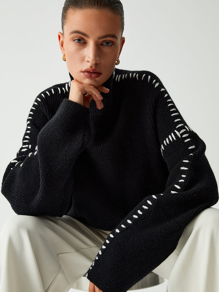 Cozy black oversized women's sweater with contrast stitching & mock neck, offering relaxed comfort for fall and winter.