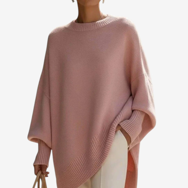 Stylish women's oversized batwing sleeve crew neck sweater with an elegant asymmetric hem. Casual & cozy.