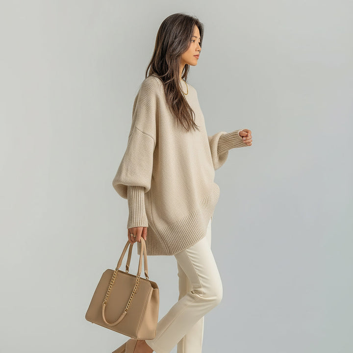 Modern women's crew neck sweater: oversized fit, chic batwing sleeves, and a distinctive asymmetric hem.