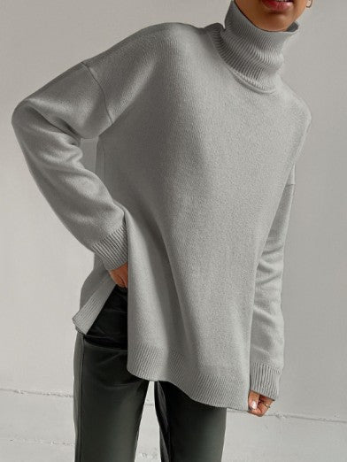 Stay warm and stylish in this women's long turtleneck sweater, designed with an oversized fit and side slit.