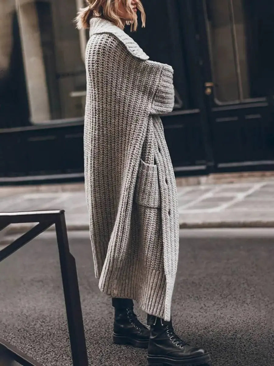 Close-up of a women's oversized longline cardigan showing soft knit fabric and elegant lapel detail. Cozy winter fashion.
