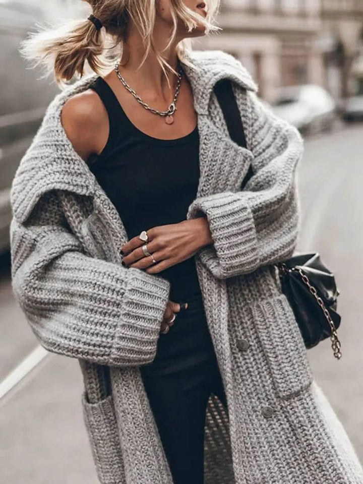 Full-length view of a women's longline cardigan, featuring an oversized fit and classic lapels for chic winter outerwear.