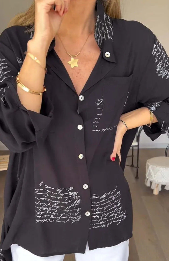 Stylish women's oversized script print button-up shirt worn for a casual yet chic look. Perfect everyday top.