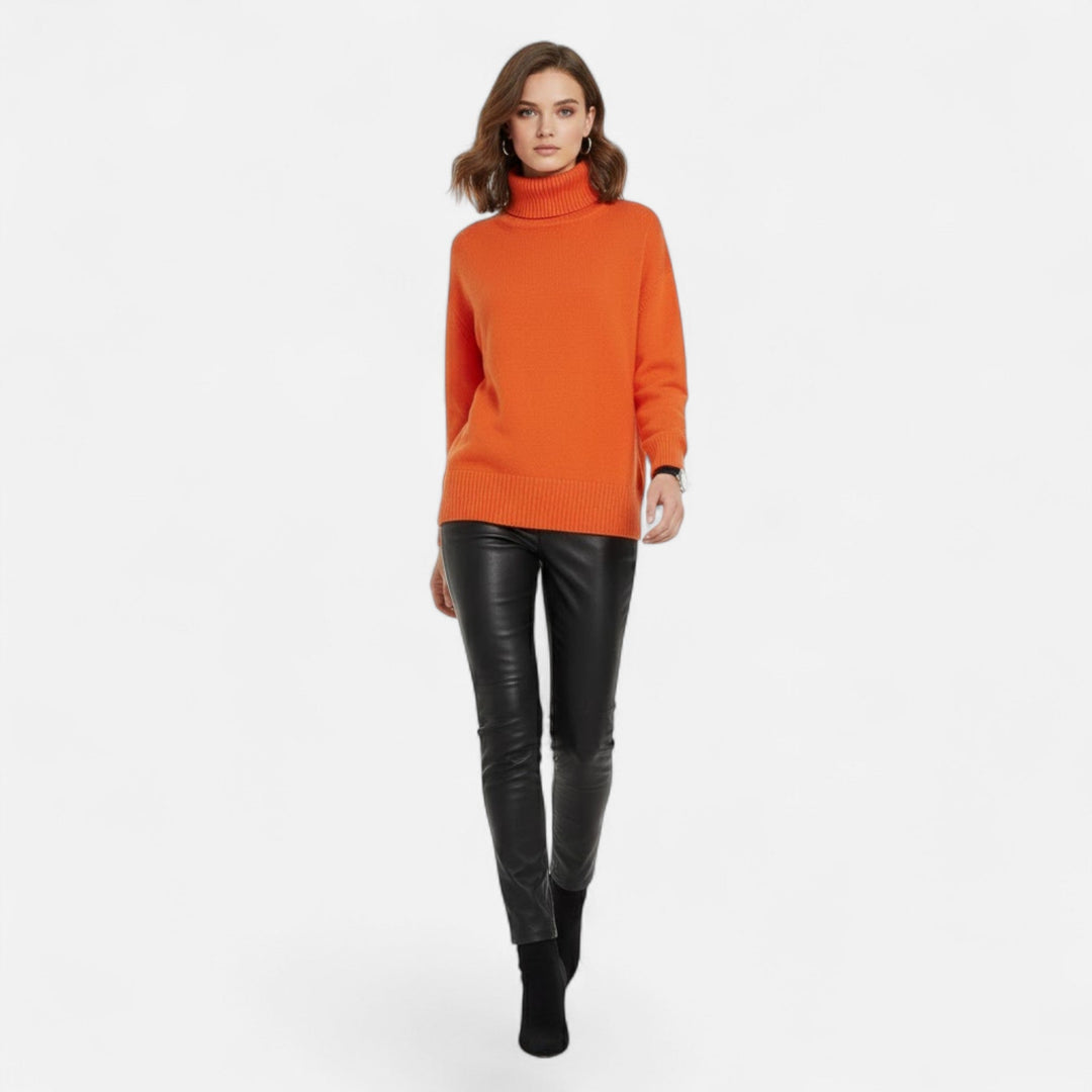 A woman enjoying the cozy feel of this oversized turtleneck knit sweater.