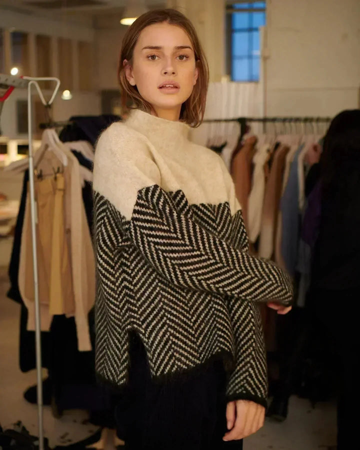 Cozy women's oversized turtleneck sweater in a comfortable knit, showcasing a stylish color block chevron design. Fall fashion.