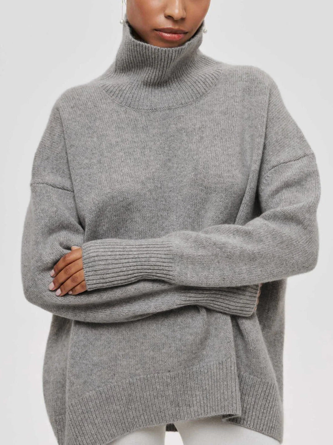 Warm and cozy oversized turtleneck sweater for women, featuring stylish elbow slits for winter fashion.