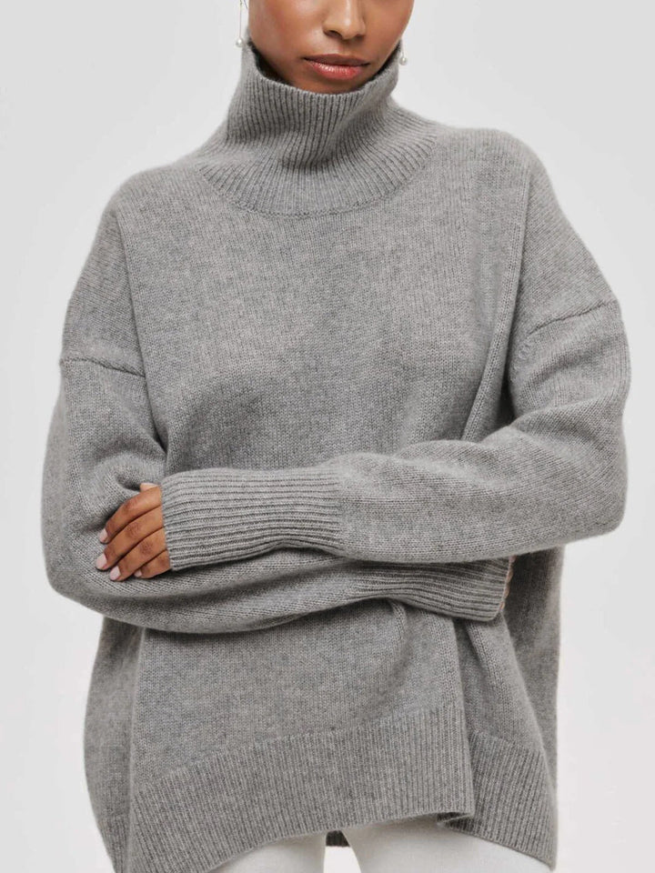 Warm and cozy oversized turtleneck sweater for women, featuring stylish elbow slits for winter fashion.