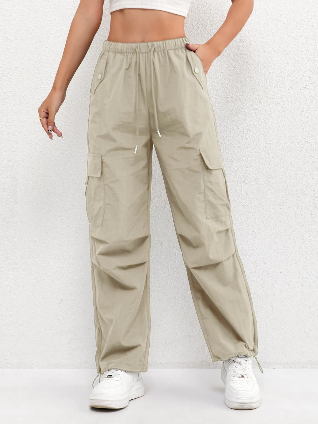 Full-length women's parachute style cargo trousers, showcasing relaxed fit, drawstring waist & multi-pockets.
