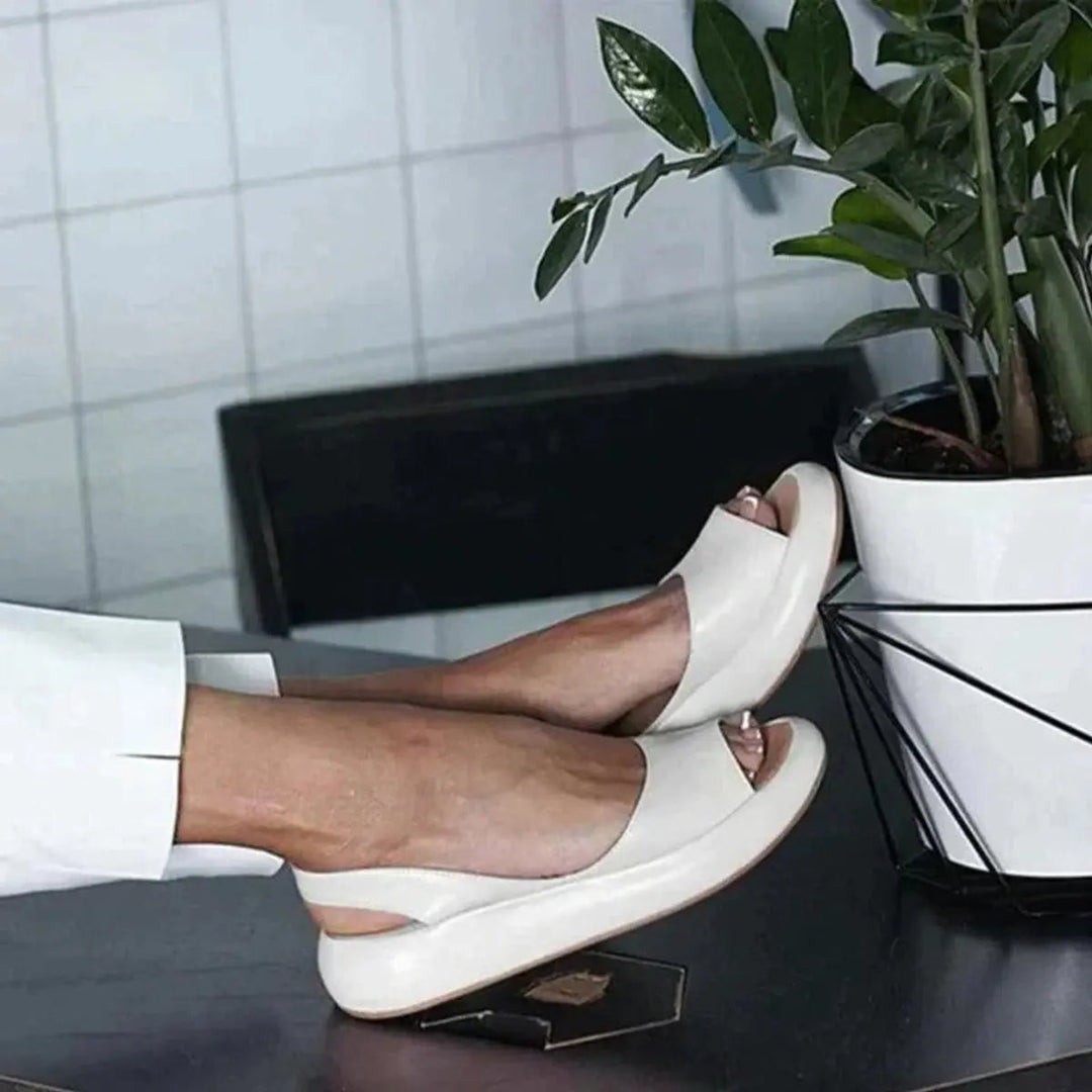 Women's cushioned flat slingback sandals with peep toe design, offering casual elegance.