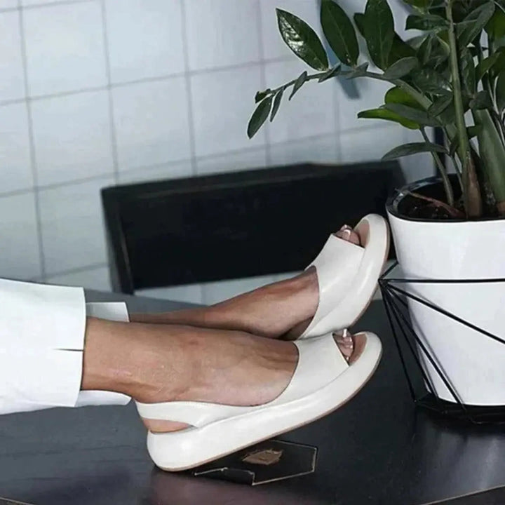 Women's cushioned flat slingback sandals with peep toe design, offering casual elegance.