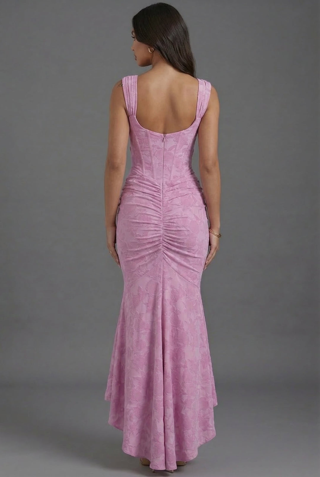 Full shot of a woman wearing a stunning pink corset and ruched fishtail maxi dress for evening wear.