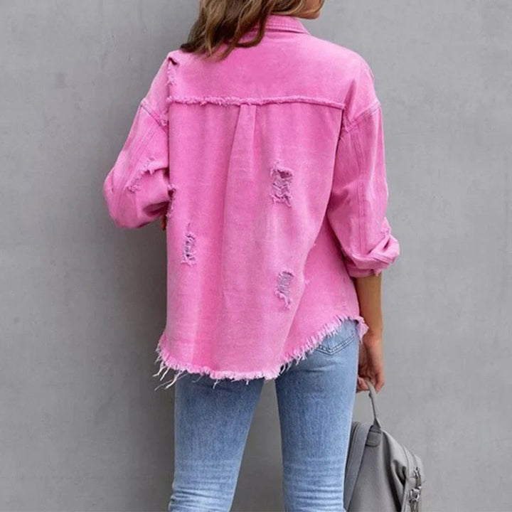 Stylish women's pink distressed denim jacket, featuring frayed edges & button-up closure for a modern casual look.