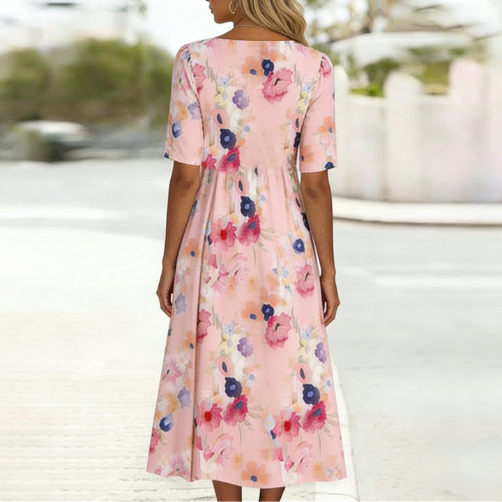 Women's vibrant floral pink midi dress, A-line silhouette with V-neck, short sleeves. Stylish spring/summer wear.