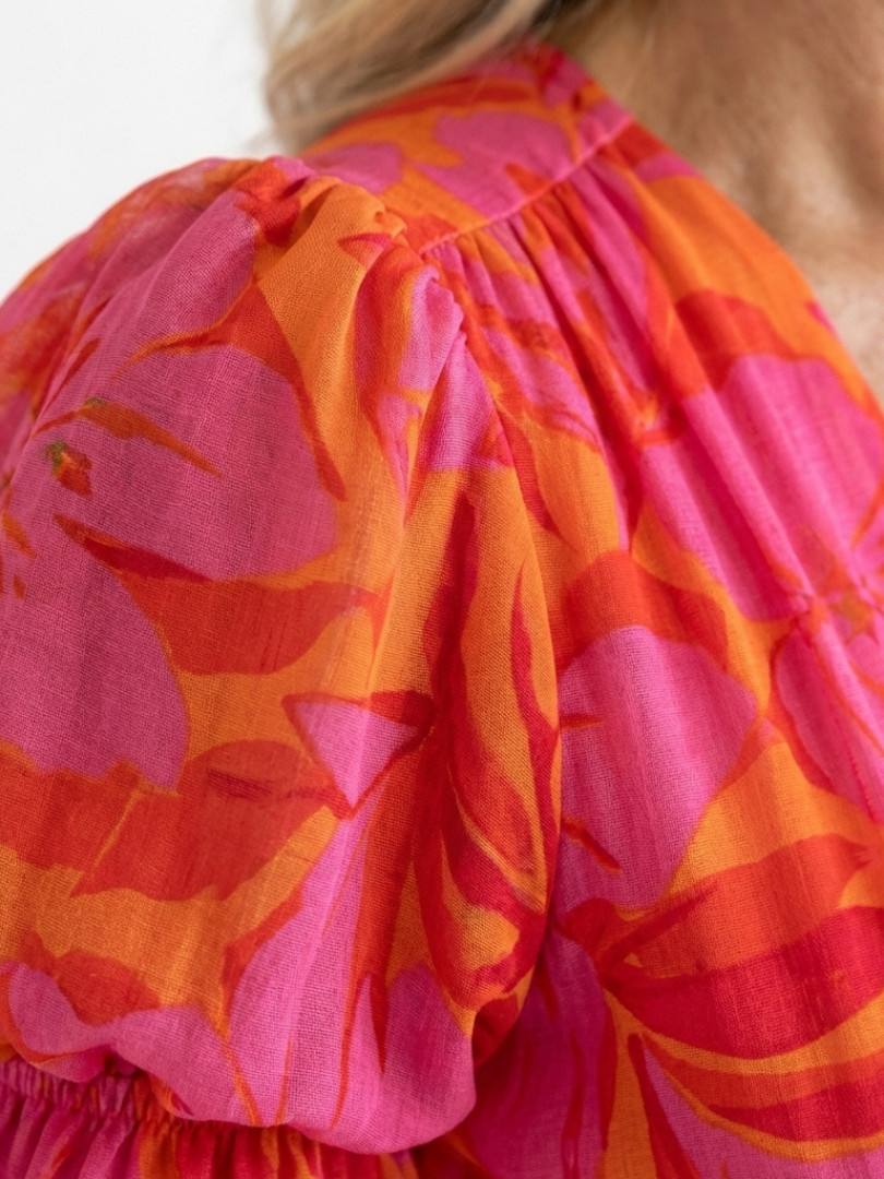 Comfortable pink floral midi dress for women. Features a relaxed fit, V-neck, and stylish puff sleeves.