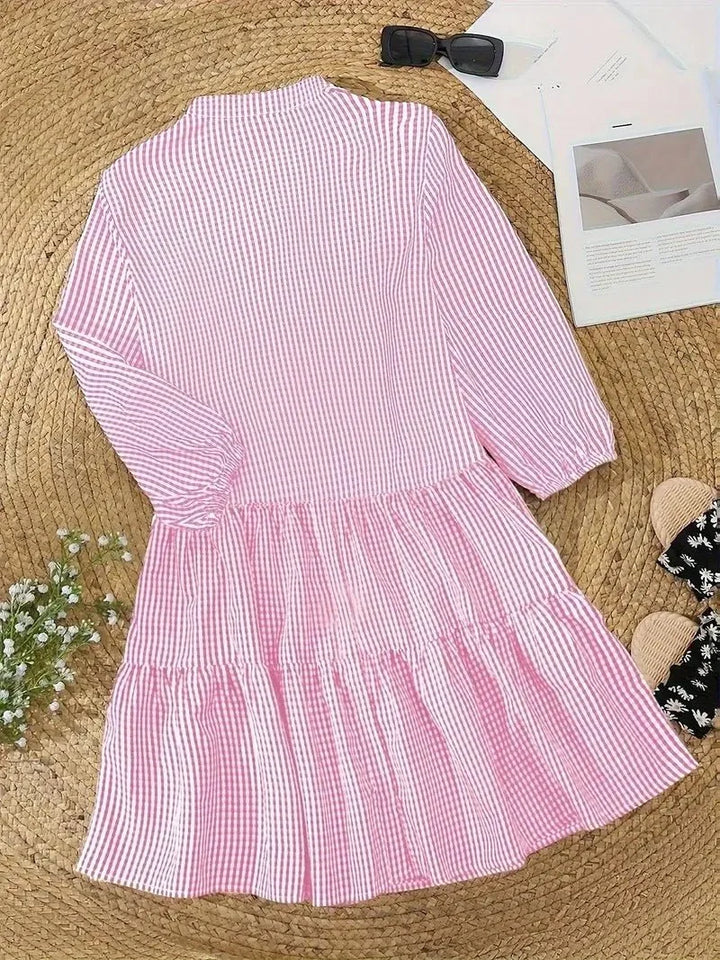 Women's flowy tiered gingham mini dress in pink, with V-neckline and 3/4 sleeves for everyday style.