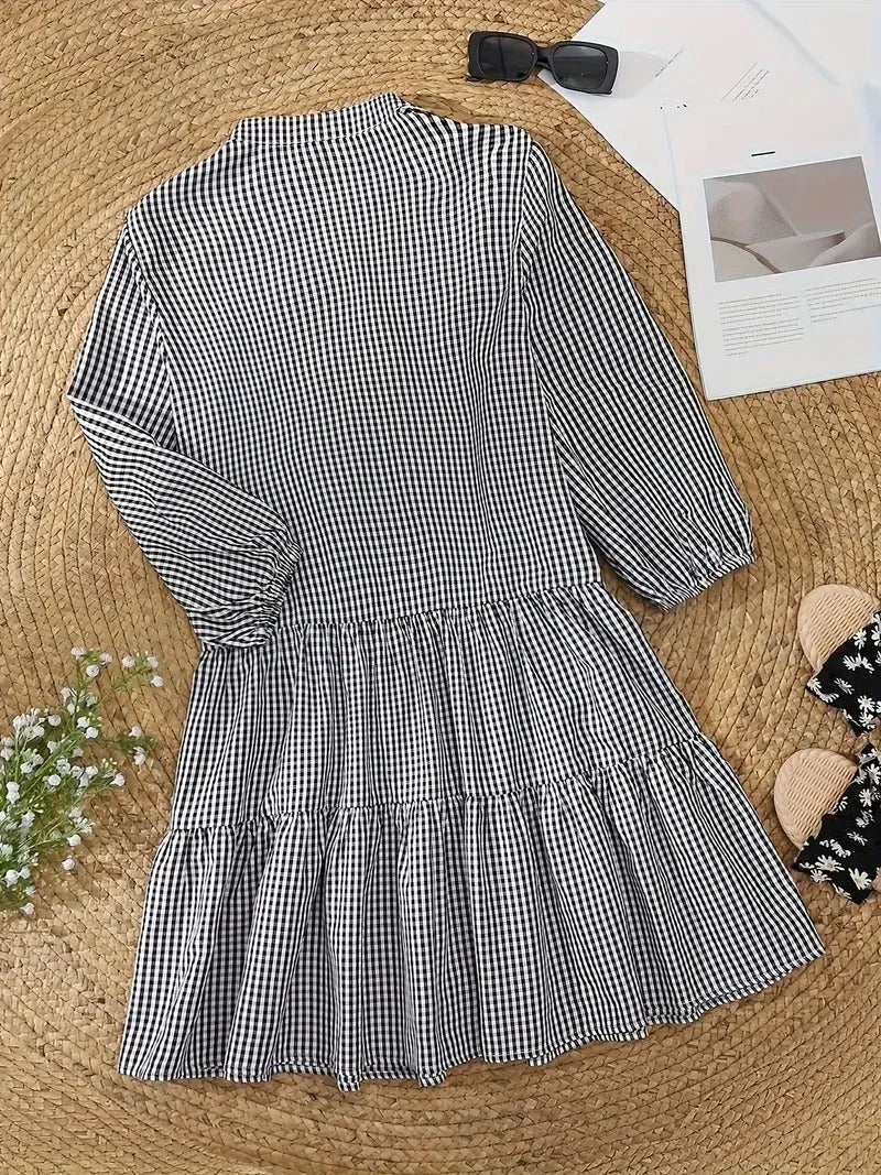 Women's black gingham V-neck tiered mini dress with 3/4 puff sleeves, ideal for casual spring fashion.
