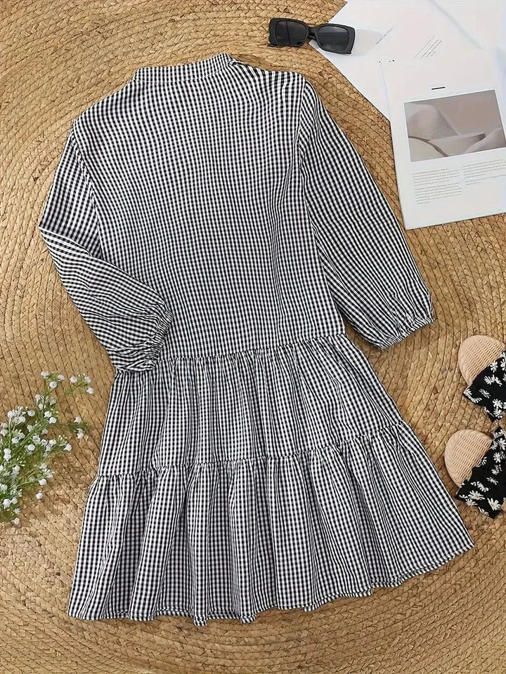 Women's black gingham V-neck tiered mini dress with 3/4 puff sleeves, ideal for casual spring fashion.