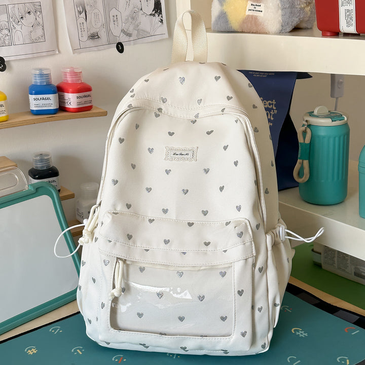 Women's pink heart-patterned school backpack, ideal for casual daily carry & college. Stylish & durable design.