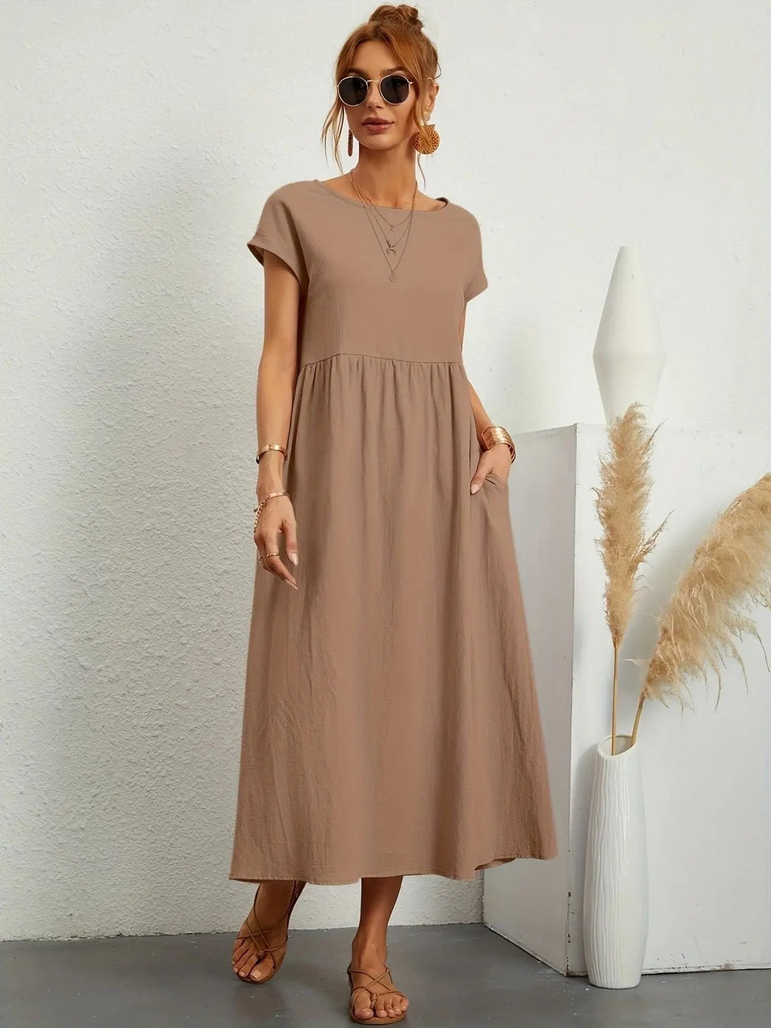 Casual women's day dress: pleated empire waist midi, short sleeve, round neck. Includes practical pockets.