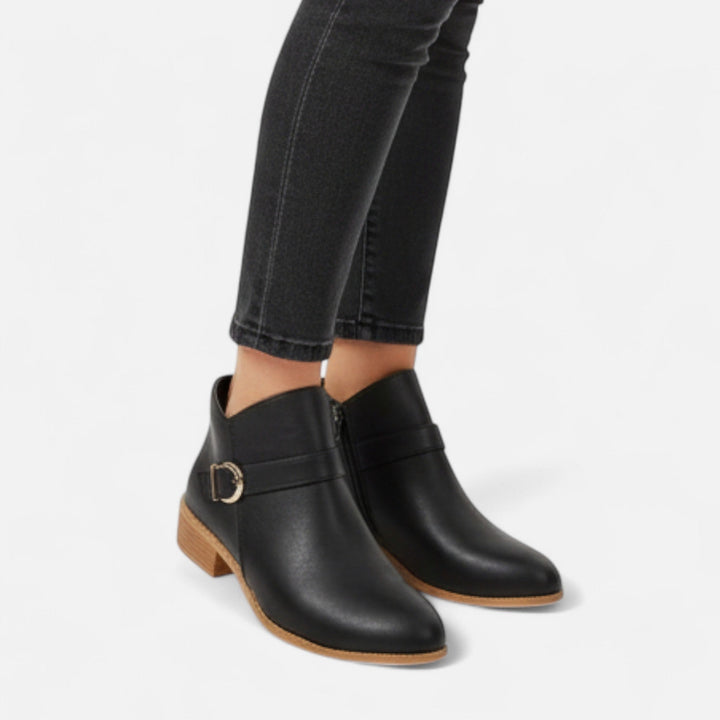 Close-up of women's pointed-toe ankle boots with stylish buckle, highlighting elegant and chic footwear design.