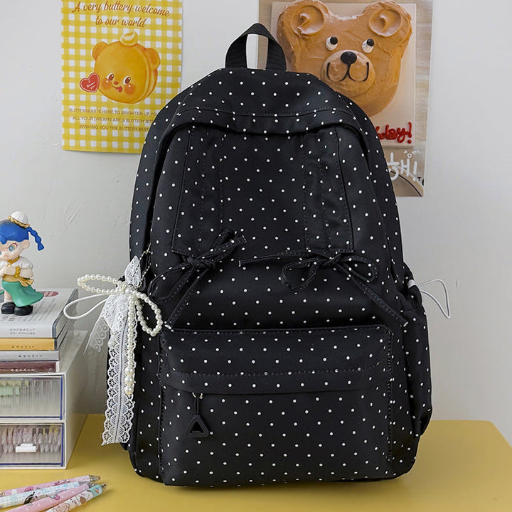 Stylish women's casual backpack with classic polka dot pattern, ideal for students.