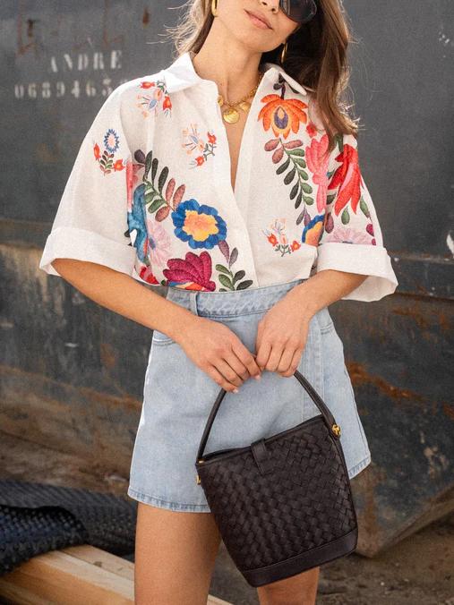 Back view of women's comfortable printed short-sleeve blouse, collared and button-front, ideal for everyday wear.