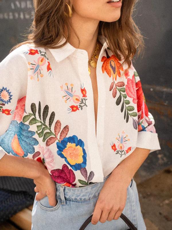 Vibrant women's printed collared blouse with short sleeves and button-front, a chic and casual summer apparel top.