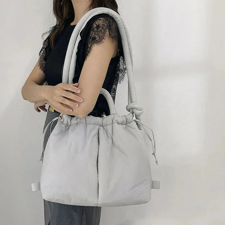 Soft women's puffer tote bag, quilted design with practical drawstring sides & chic knot strap.