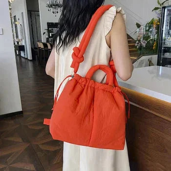 Everyday women's quilted puffer shoulder bag. Features drawstring sides and a unique knot-detail strap.