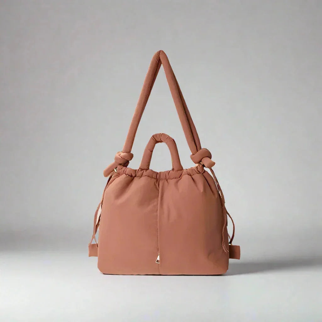 Side view of the women's puffer tote bag, highlighting the adjustable drawstring sides & quilted texture.
