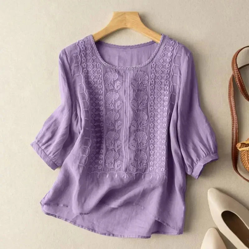 Comfortable women's top: floral embroidered relaxed blouse with fashionable puff sleeves, ideal for summer style.
