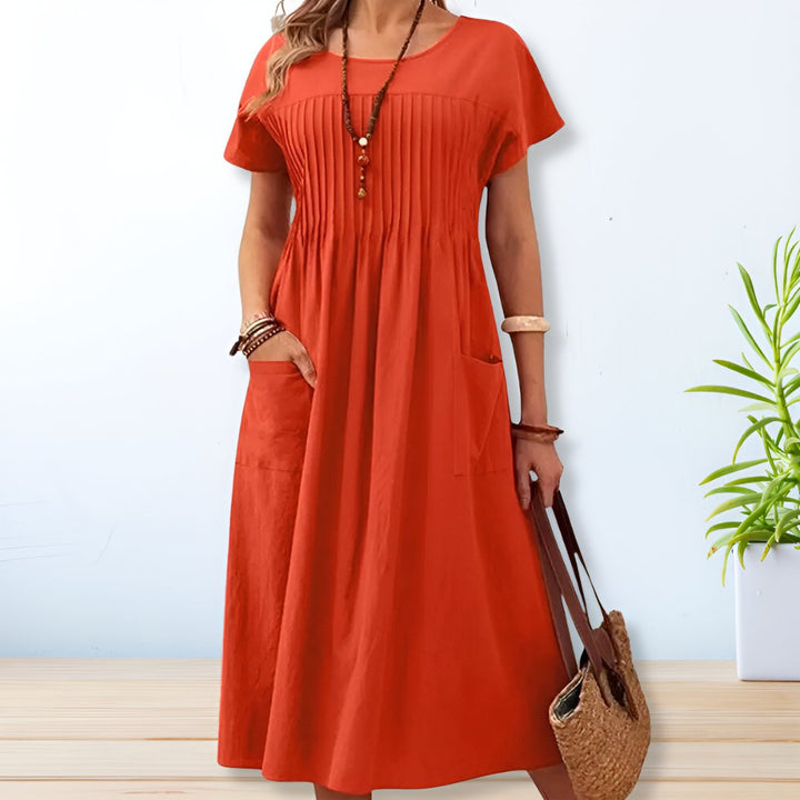 Flowy blue relaxed fit day dress for women, offering tummy coverage, short sleeves, and pockets for casual comfort.